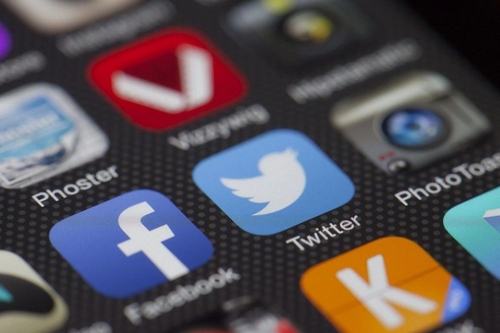 A zoomed in photo of a smartphone's homescreen that shows Facebook and Twitter app, while other apps were blurred. 
