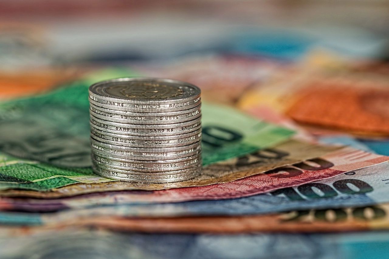 A photo of cash bills and stacked up coins. 
