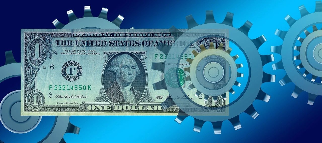 A visual of a $1 US money with gears on the background. 