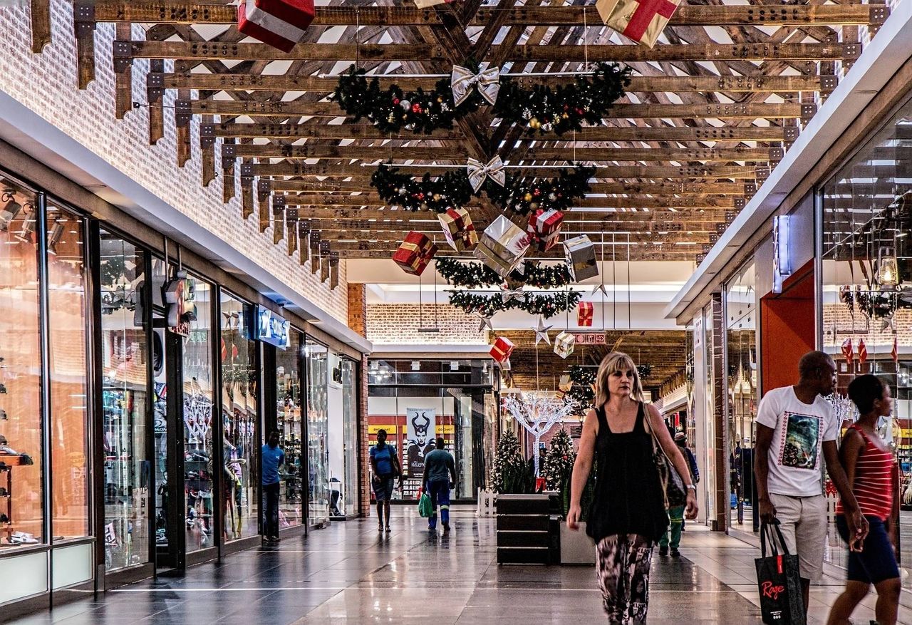 A snapshot of an inside of a mall during holidays with different people/shoppers.